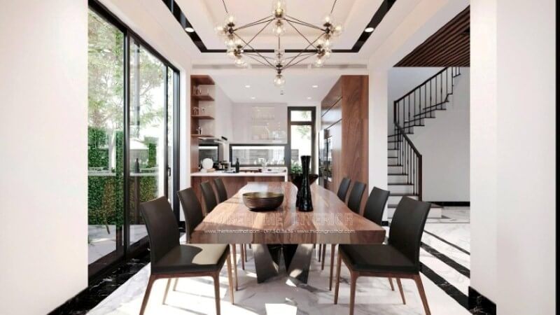 Không chỉ là nơi để mọi người thưởng thức những tinh hoa ẩm thực từ người mẹ, người vợ, người bà,.. mà còn là nơi để gia đình vun đắp nên mái ấm hạnh phúc. Việc chú tâm vào bố trí một không gian phòng ăn biệt thự lại càng được chú trọng để tạo nên điều kiện tốt nhất cho tất cả mọi người trong gia đình. Việc bố trí, lựa chọn đồ nội thất hợp với lối sống, gu thẩm mỹ và bố trí ánh sáng lại ngày càng được chú trọng. Tùy từng sở thích của mỗi gia đình mà sẽ có những ý tưởng thiết kế nội thất phòng ăn phù hợp chẳng hạn với ý tưởng thiết kế nội thất không gian phong cách hiện đại trong biệt thự Vinhomes Imperia Hải Phòng. Chất liệu gỗ đặc biệt là gỗ óc chó được thể hiện liền mạch dọc tầm nhìn khi đi từ phòng khách, chiếc bàn gỗ óc chó nguyên tấm, chiếc ghế bọc da sử dụng khung gỗ óc chó, dóng sang hai bên là tủ bếp gỗ óc chó, cùng kệ để đồ bắt mắt.
